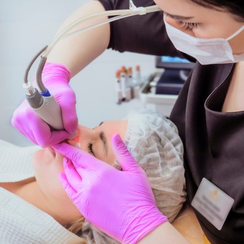 Professional female cosmetologist doing hydrafacial procedure in Cosmetology clinic. Doctor use hydra vacuum cleaner. Rejuvenation And Hydratation. Cosmetology